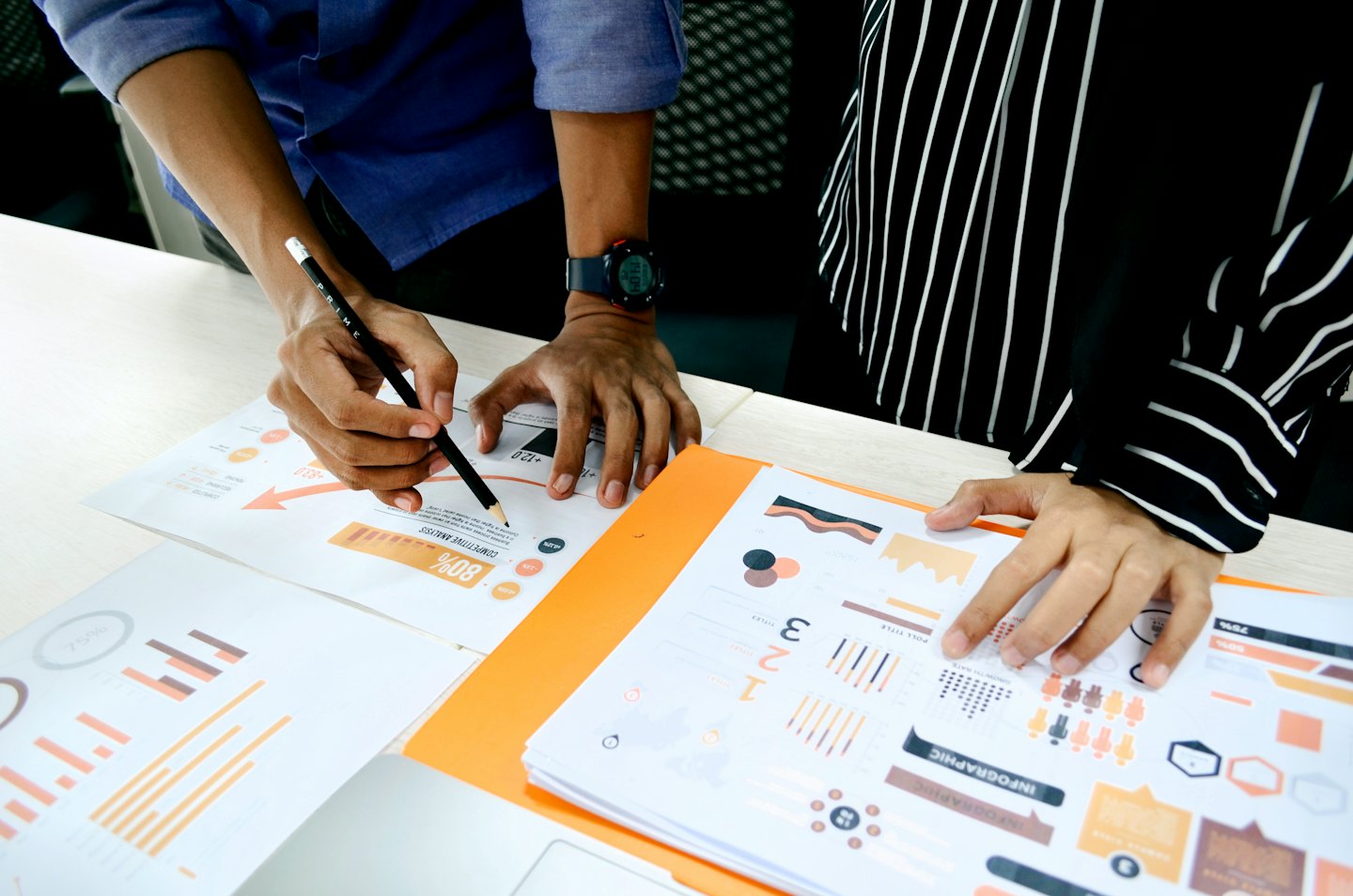 Two colleagues analyzing business documents and charts together.